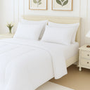 Elegant neutral comforter set laid out in bedroom showing texture and coordinated pillow accents