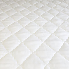 Close‑up of the mattress protector fabric, highlighting soft, lightweight texture and waterproof backing.