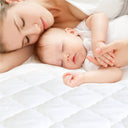 Detail shot of the fitted mattress protector’s elastic edge hugging a king mattress corner for secure non‑slip fit.